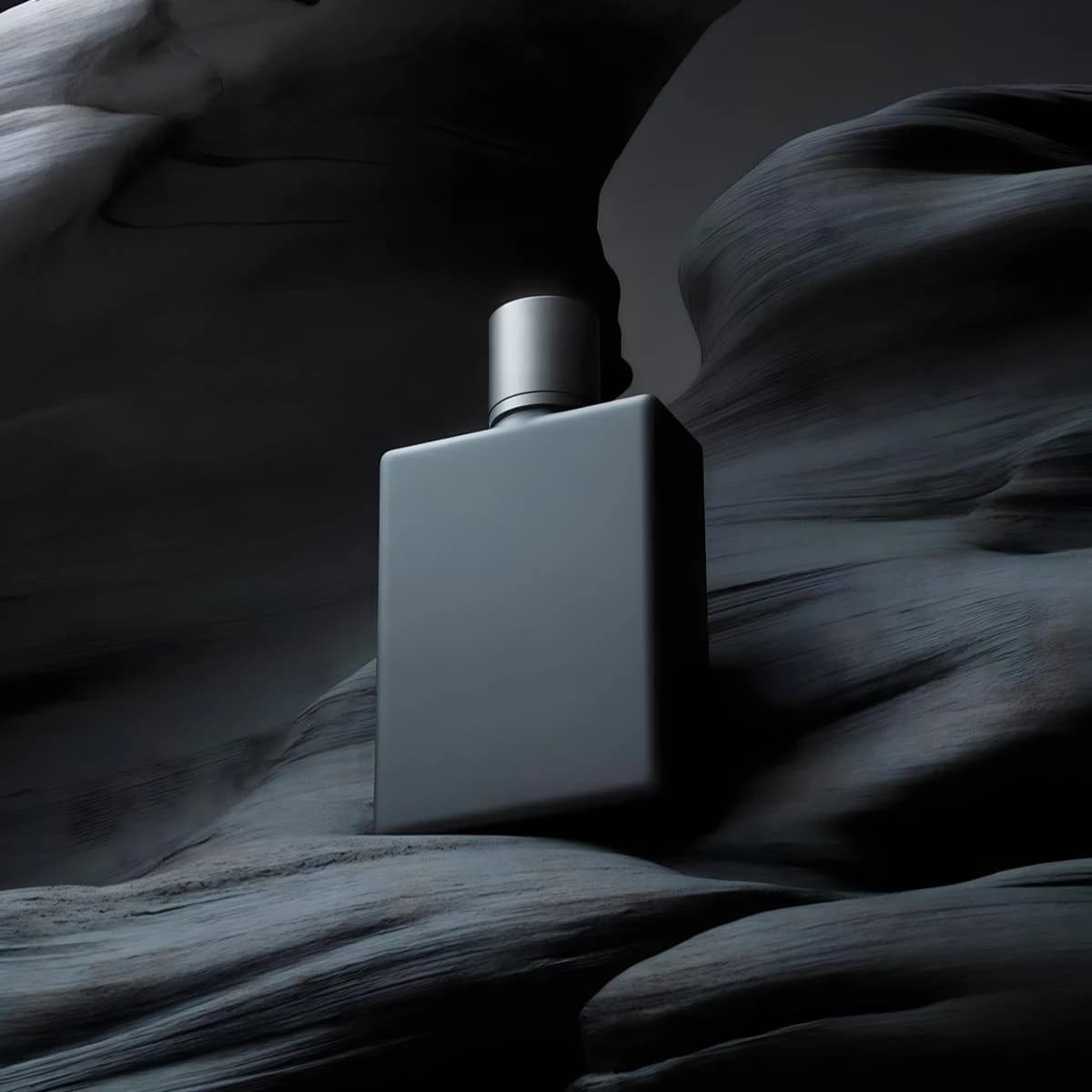 Matte grey perfume bottle against dark stone